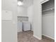 A well-lit laundry room features a washer, dryer, shelf, and gray tile flooring at 6868 Sky Pointe Dr # 2035, Las Vegas, NV 89131