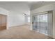 Bright living area featuring carpet, balcony access, and a view of the front door at 6955 N Durango Dr # 1093, Las Vegas, NV 89149