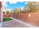 Fully fenced backyard featuring low maintenance landscaping of brick pavers, crushed stone and synthetic grass at 7342 Brisbane Hills St, Las Vegas, NV 89166