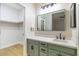 Modern bathroom with green vanity, a sink, and a large mirror at 7342 Brisbane Hills St, Las Vegas, NV 89166