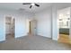 Bright bedroom featuring neutral carpet and paint, ceiling fan, and access to the ensuite bath at 7342 Brisbane Hills St, Las Vegas, NV 89166