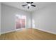 Bright bedroom featuring wood floors, a ceiling fan and sliding doors at 7342 Brisbane Hills St, Las Vegas, NV 89166