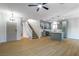 Open-concept living space with wood floors, staircase, and modern kitchen with island at 7342 Brisbane Hills St, Las Vegas, NV 89166