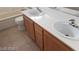 Bathroom features a double sink vanity with wood cabinets and tile flooring at 7517 Apple Cider St, Las Vegas, NV 89131
