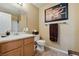 Traditional bathroom with a single sink vanity, white toilet, and framed art at 7701 W Robindale Rd # 274, Las Vegas, NV 89113