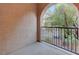 This inviting balcony offers a peaceful view, highlighted by an elegant arched entrance and iron railing, creating a cozy outdoor retreat at 7856 Carysford Ave, Las Vegas, NV 89178