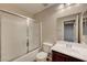 Bathroom featuring white sink, toilet, vanity and frosted glass enclosed shower and tub at 7856 Carysford Ave, Las Vegas, NV 89178