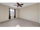 Neutral bedroom with large window, ceiling fan, and carpeted flooring; ready for your personal touch to make it home at 7856 Carysford Ave, Las Vegas, NV 89178