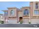 Attractive townhome featuring a private garage, arched entryway, and charming architectural details at 7856 Carysford Ave, Las Vegas, NV 89178