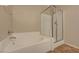 Bright main bathroom featuring a soaking tub, glass enclosed shower, tile floor and private access to a walk-in closet at 7856 Carysford Ave, Las Vegas, NV 89178