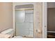 A bathroom with gold-toned sliding glass shower doors and marble-look wallpaper at 819 Sandsprings St, Henderson, NV 89011