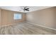 A bedroom features neutral paint, wood-look flooring, and bright window at 819 Sandsprings St, Henderson, NV 89011