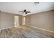 Spacious bedroom with wood-look flooring, ceiling fan, neutral paint, and ensuite bath at 819 Sandsprings St, Henderson, NV 89011