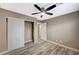A bedroom with ceiling fan, wood-look flooring, closet, and ensuite bathroom at 819 Sandsprings St, Henderson, NV 89011