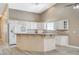 Bright kitchen featuring a large island, white cabinets, modern appliances, and wood-look flooring at 819 Sandsprings St, Henderson, NV 89011