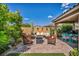 Spacious backyard featuring a cozy seating area, fire pit, and lush landscaping at 8346 Vinamala Ave, Las Vegas, NV 89149