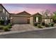 Charming single-story home with a two-car garage, paved driveway, and desert landscaping at dusk at 8346 Vinamala Ave, Las Vegas, NV 89149