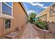 Cozy side yard with desert landscaping, including stones, pavers, plants, and a decorative brick wall at 8346 Vinamala Ave, Las Vegas, NV 89149