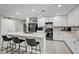 Modern kitchen features an island with seating, sleek white cabinets, and stainless steel appliances at 8346 Vinamala Ave, Las Vegas, NV 89149
