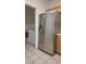 Laundry area showcasing stainless steel refrigerator, washer, dryer, and storage shelving, set on tile floor at 8725 W Flamingo Rd # 216, Las Vegas, NV 89147