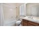 Bathroom with a shower-tub combo, wooden vanity, and neutrally colored tile at 9236 Whitekirk Pl, Las Vegas, NV 89145