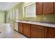 Kitchen with tile flooring, wood cabinets, and a white dishwasher by a bright window at 9236 Whitekirk Pl, Las Vegas, NV 89145