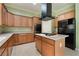 Gourmet kitchen features a black fridge, wooden cabinets, and center island gas cooktop at 9236 Whitekirk Pl, Las Vegas, NV 89145