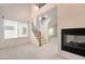 Bright living room with fireplace, windows, and open staircase at 9236 Whitekirk Pl, Las Vegas, NV 89145