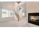Bright living room with fireplace, windows, and open staircase at 9236 Whitekirk Pl, Las Vegas, NV 89145