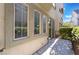 Relaxing patio with lush green landscaping and a sliding glass door at 9236 Whitekirk Pl, Las Vegas, NV 89145