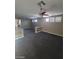 Spacious living room featuring dark carpet, tan walls, and bright windows with plantation shutters at 9622 Staff Ln, Las Vegas, NV 89178