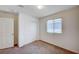 This bedroom features neutral carpet, white walls and doors, a window, and a double door closet at , Henderson, NV 89011