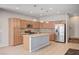 Bright kitchen features wooden cabinets, stainless steel appliances, a central island, and tiled backsplash at , Henderson, NV 89011