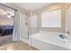 Bright bathroom features a shower, tub, and view into the bedroom through the doorway at 10733 Red Badge Ave, Las Vegas, NV 89166