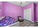 Bright bedroom features contemporary gray wood laminate flooring and a closet with paneled doors at 10733 Red Badge Ave, Las Vegas, NV 89166