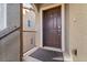 Entryway featuring a dark brown front door, neutral stucco siding, and metal railing, creating a welcoming entrance at 10733 Red Badge Ave, Las Vegas, NV 89166