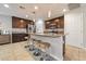 Modern kitchen boasts stainless steel appliances, dark cabinetry, and a large island with barstool seating at 10733 Red Badge Ave, Las Vegas, NV 89166