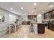 Well-lit kitchen with stainless steel appliances, granite counters, island with seating, and dining area at 10733 Red Badge Ave, Las Vegas, NV 89166