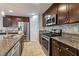 Bright kitchen includes a center island, stainless steel appliances and dark wood cabinets and drawers at 10733 Red Badge Ave, Las Vegas, NV 89166