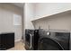 Efficient laundry room with modern washer and dryer, storage space and convenient shelving for organization at 10733 Red Badge Ave, Las Vegas, NV 89166
