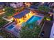 Aerial view of community pool with lounging area, covered patio, hot tub, and well-manicured landscaping at twilight at 10733 Red Badge Ave, Las Vegas, NV 89166