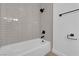 Modern bathroom featuring a sleek tub with tiled surround and black fixtures at 1108 Putnam Ave, North Las Vegas, NV 89030