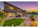 Expansive backyard featuring a green lawn, covered patio, and meticulous desert landscaping at 11334 Patores St, Las Vegas, NV 89141
