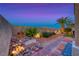 Landscaped backyard featuring decorative rock and brick, desert plants, accent lighting, and privacy walls at 11334 Patores St, Las Vegas, NV 89141