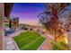 Stylish backyard with green grass, a brick patio, desert landscaping, and mountain views at 11334 Patores St, Las Vegas, NV 89141
