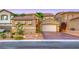 Inviting home features desert landscaping, an attached two-car garage, and a private front yard at 11334 Patores St, Las Vegas, NV 89141