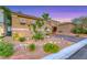 Well-kept yard with gravel landscaping surrounding a tan home featuring a tile roof at 11334 Patores St, Las Vegas, NV 89141