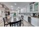 Bright kitchen boasts white cabinetry, stainless appliances, wine fridge and adjacent dining area at 11334 Patores St, Las Vegas, NV 89141