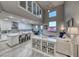 Bright, open-concept living room and kitchen with stainless steel appliances and modern white cabinets at 11334 Patores St, Las Vegas, NV 89141