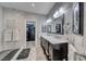 Bright main bathroom with dual sinks, a walk-in shower and a walk-in closet at 11334 Patores St, Las Vegas, NV 89141